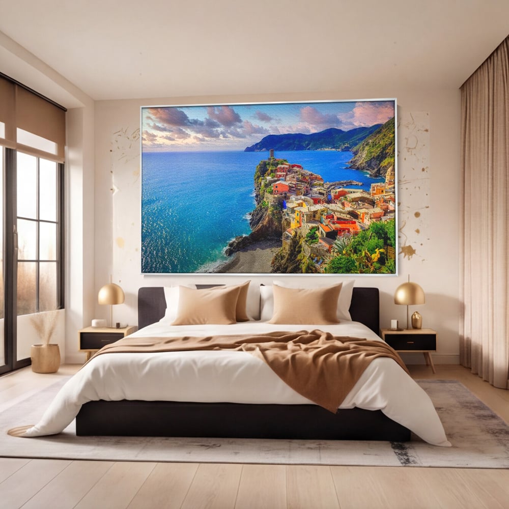 Tablou canvas cu peisaj costier italian cu sat colorat pe stanca, in rama de aluminiu argintiu, pe perete intr-un dormitor